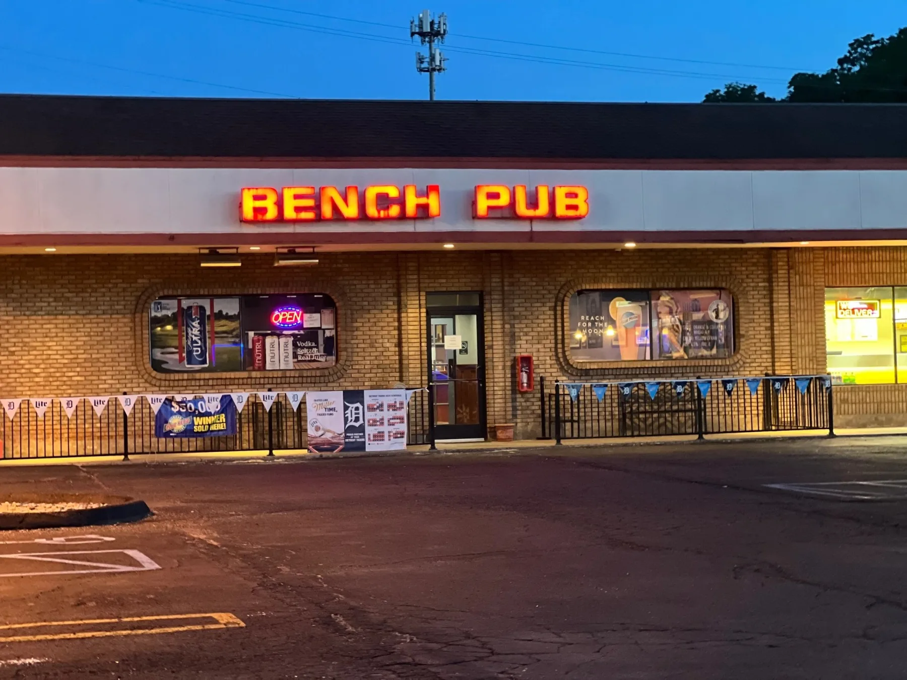 The Bench Pub storefront on Five Mile Road in Livonia lit up at dusk
